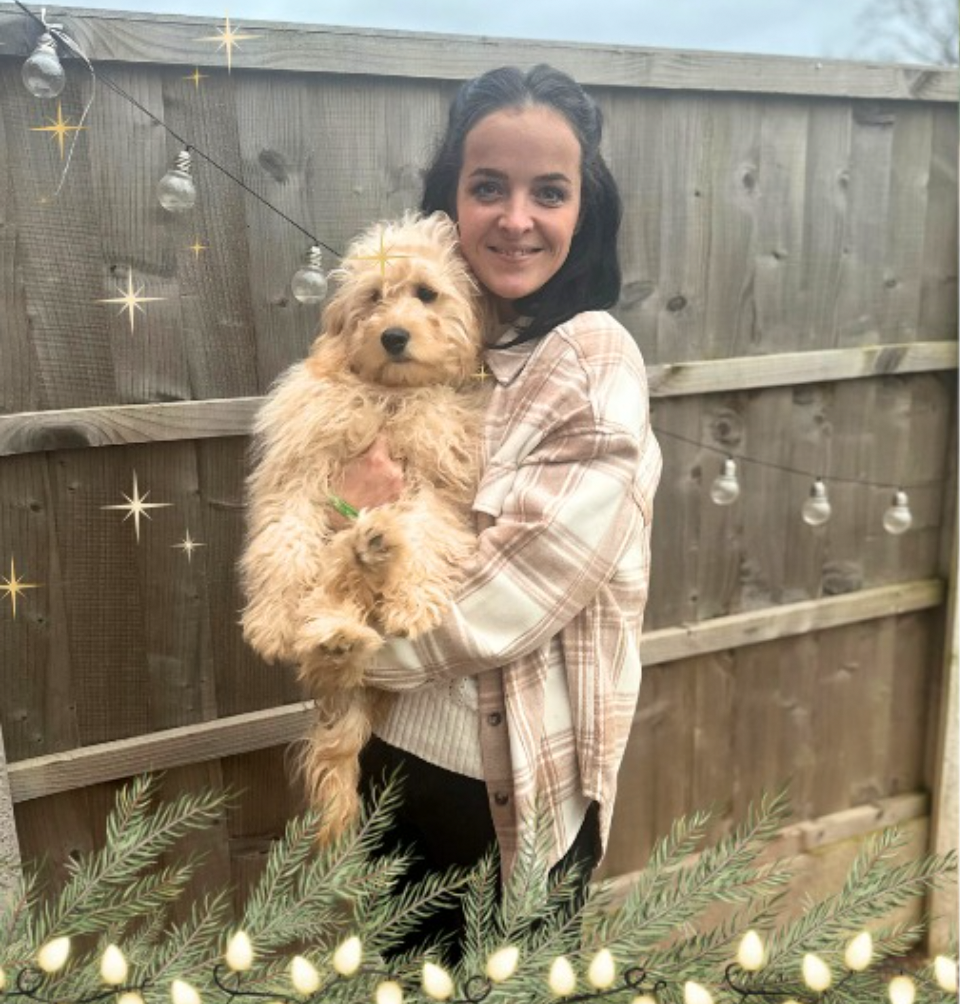 Crystal & Alfie standing in front of a fence